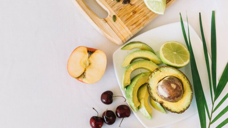 Composição natural com 5 alimentos funcionais: frutas vermelhas, peixe, abacate, cúrcuma e folhas verdes, utilizados na prevenção de doenças crônicas.