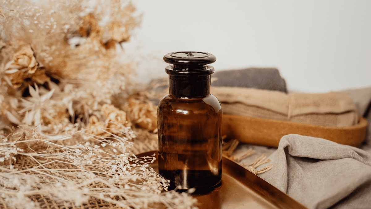 Frascos de biocosméticos com embalagens sustentáveis sobre fundo de linho cru, acompanhados de folhas verdes, flores naturais e ingredientes vegetais como lavanda, aloe vera, argila e óleos essenciais.